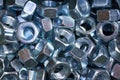 A pile of galvanized industrial nuts. Metal nut texture, industrial background. Macro photo.