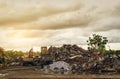 Pile of garbage and backhoe at waste depot. Rubbish recycling business. Heap of plastic waste, wood scrap, and old rusty metal at