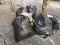Pile garbage black bag plastic on roadside.Trash bag on the footpath.