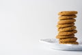 A pile of gingerbread cookies on a white plate and white background with copy space Royalty Free Stock Photo