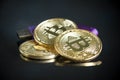 Pile of gold bitcoin cryptocurrency coins with purple digital ha