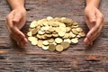 pile of gold coin with woman hand on the wooden background fina Royalty Free Stock Photo