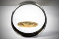 A pile of gold coins of various sizes is visible in a magnifying glass Royalty Free Stock Photo
