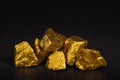 A pile of gold nuggets or gold ore on black background, precious Royalty Free Stock Photo