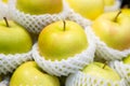 Pile of golden Apple wrapped with foam net in fresh market Royalty Free Stock Photo