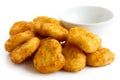 Pile of golden deep-fried battered chicken nuggets with empty bo