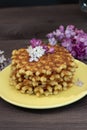 Pile of golden homemade waffles on a saucer, vertical photo