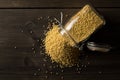 Pile of golden millet, a gluten free grain seed, in glass storage jar on dark table background flat lay from above Royalty Free Stock Photo