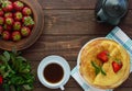 Pile of golden pancakes with strawberries and strawberry jam, decorative sprig of mint. Royalty Free Stock Photo