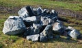 Pile of gray stones in the meadow. workers are catching stones to use on a rock garden in the park. quarry unworked irregular piec