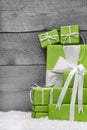 Pile of green Christmas presents, with snow on grey Royalty Free Stock Photo