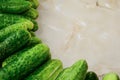 A pile of green cucumbers stacked in rows on the table.