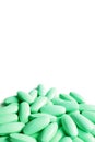 Pile of green pills on white background with copy space