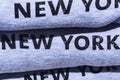 Pile of grey cotton sweatshirts with printed inscription - New York, exposed on tourist shop. Visiting NY conception.