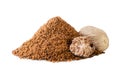Pile of ground nutmeg and a piece close-up on a white background. Isolated Royalty Free Stock Photo