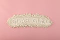 Pile of Guar gum powder or guaran on pink background. Food additive E412. Inscription GUAR GUM. Design element. Thickening agent.