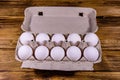 Pile of the hen eggs in paper tray on wooden table