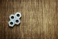 Pile of a hexagon nut on old wood background.