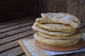 Pile of homemade flat bread on a wooden background. Mexican flatbread taco. Indian Naan. Space for text