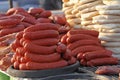 Pile of homemade raw sausages and baked bread - purlenka. Raw sausages and bread prepared for grill. Fast food outside.