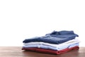 Pile of ironed clothes on table against white