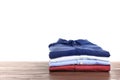 Pile of ironed clothes on table against white background Royalty Free Stock Photo