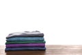 Pile of ironed clothes on table against white background Royalty Free Stock Photo