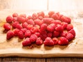 Pile of juice fresh rasberry on a wooden board. Sun flare. Fresh tasty desert product