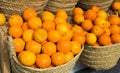 Pile of juicy oranges in wicker baskets on market counter Royalty Free Stock Photo