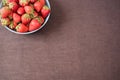 Pile of juicy ripe organic fresh strawberries in a large blue bowl. Dark background. Empty space Royalty Free Stock Photo