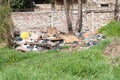 Pile of junk and garbage dumped in the nature or park in the city polluting the environment with bad smell Royalty Free Stock Photo