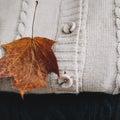 Pile of knitted  clothes on wooden background, sweaters, knitwear, leaf. Cozy autumn, winter concept. Knitted wool sweaters Royalty Free Stock Photo