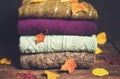 Pile of knitted winter clothes on wooden background covered with