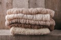 Pile of knitted winter clothes on wooden background, sweaters, knitwear, space for text, winter fall autumn concept. Royalty Free Stock Photo