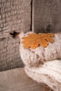 Pile of knitted winter clothes on wooden background, sweaters, knitwear, yellow leaves, space for text, winter fall autumn concept Royalty Free Stock Photo