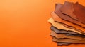 Pile of leather scraps on vibrant orange background, texture, materials, and design inspiration for creative projects Royalty Free Stock Photo