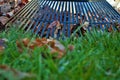 Pile of leaves and a rake leaning against a fence fall background