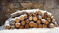 A Pile of Logs Covered in Snow Against a Stone Wall Royalty Free Stock Photo