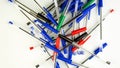 Pile of a lot multi colored plastic ballpoint pens on white background. Abstract stationery background. Top view. Close-up