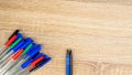 Pile of a lot multi colored plastic ballpoint pens on wooden table. Abstract stationery background. Top view, flat lay. Copy space