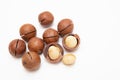 Pile macadamia nuts open kernels and shells on white background, top view