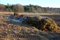 A pile of manure ready to spread across the field. in winter it emits heat which is visible in the form of a steaming cloud. straw
