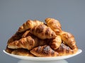 Pile Of Many Fresh Baked French Croissants On White Plate On White Background In Bright Sunlight