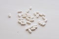 Pile of many oval white drug pills laying in a pile