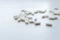 Pile of many oval white drug pills laying in a pile