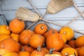 Pile of many ripe orange bright pumpkins against rustic straw hay broomstick at pumpkin farm yard. Halloween Royalty Free Stock Photo