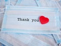 A pile medical face masks with the word `Thank you` and red heart.