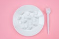 A pile of medical pills with a fork on a plate on a pink background. Pill overdose concept Royalty Free Stock Photo