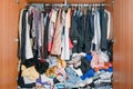 Pile of messy clothes in closet. Untidy cluttered woman wardrobe Royalty Free Stock Photo