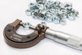 Pile of metal nuts and analog micrometer Royalty Free Stock Photo